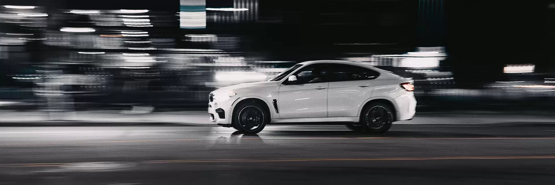 White 4x4 BMW driving in long exposure background