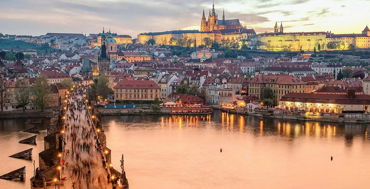 The iconic Charles Bridge in Prague, Czech Republic, adorned with statues and bustling with visitors against a scenic backdrop.