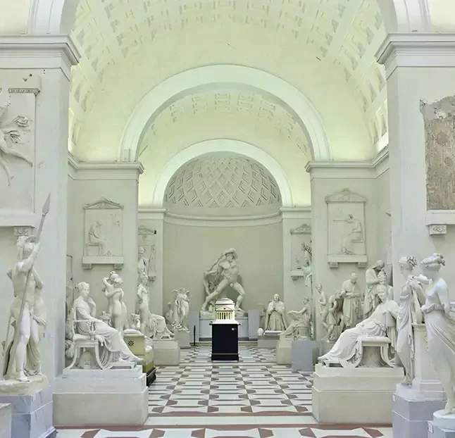 A spacious gallery featuring various statues elegantly displayed throughout the room, showcasing artistic craftsmanship.