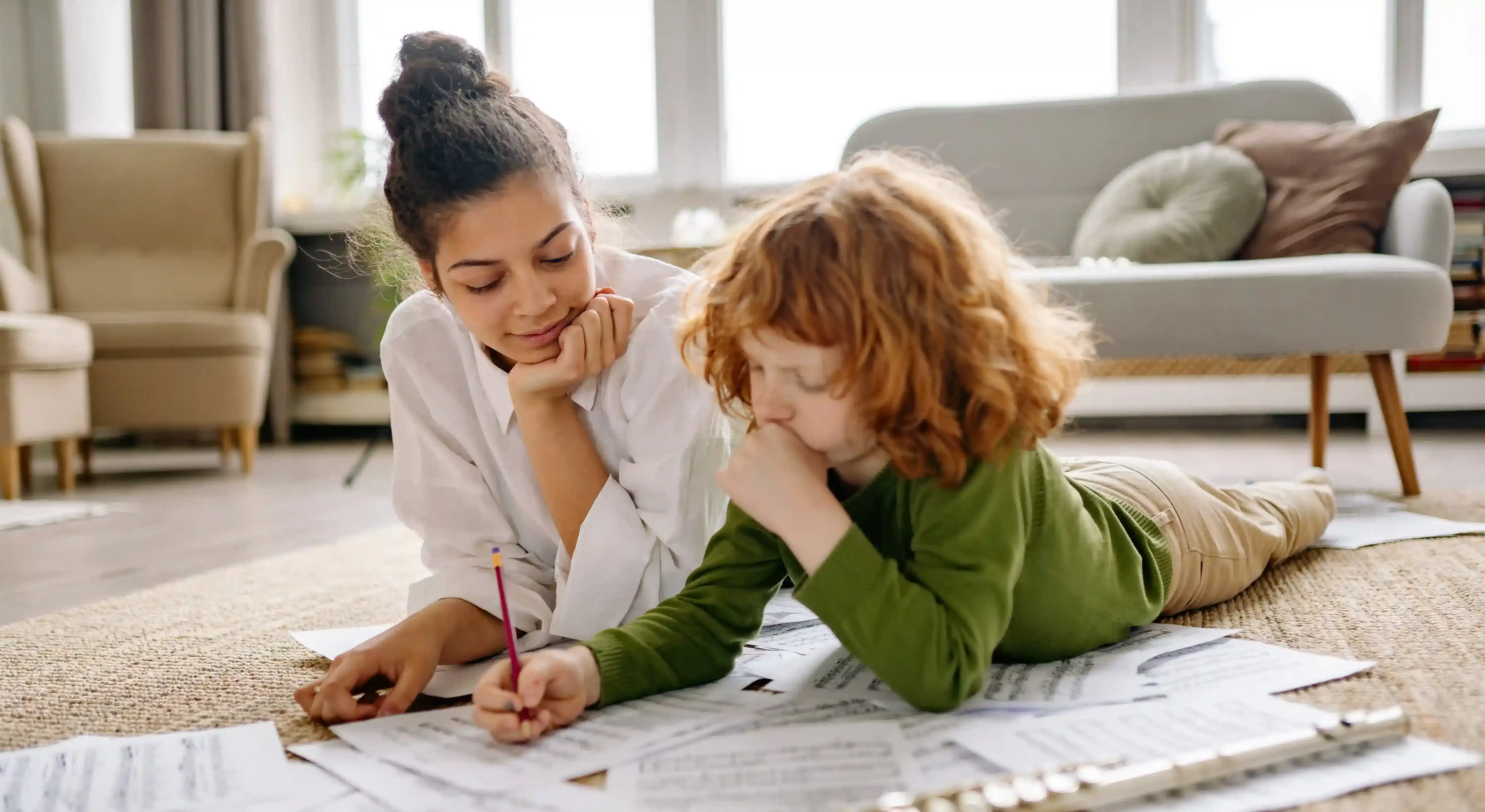 Female laying on the floor of chic lounge room with child writing on papers