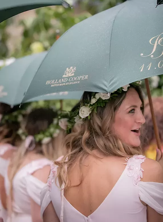 Women with flower headpiece with Holland and Cooper umbrella | Quintessentially Weddings