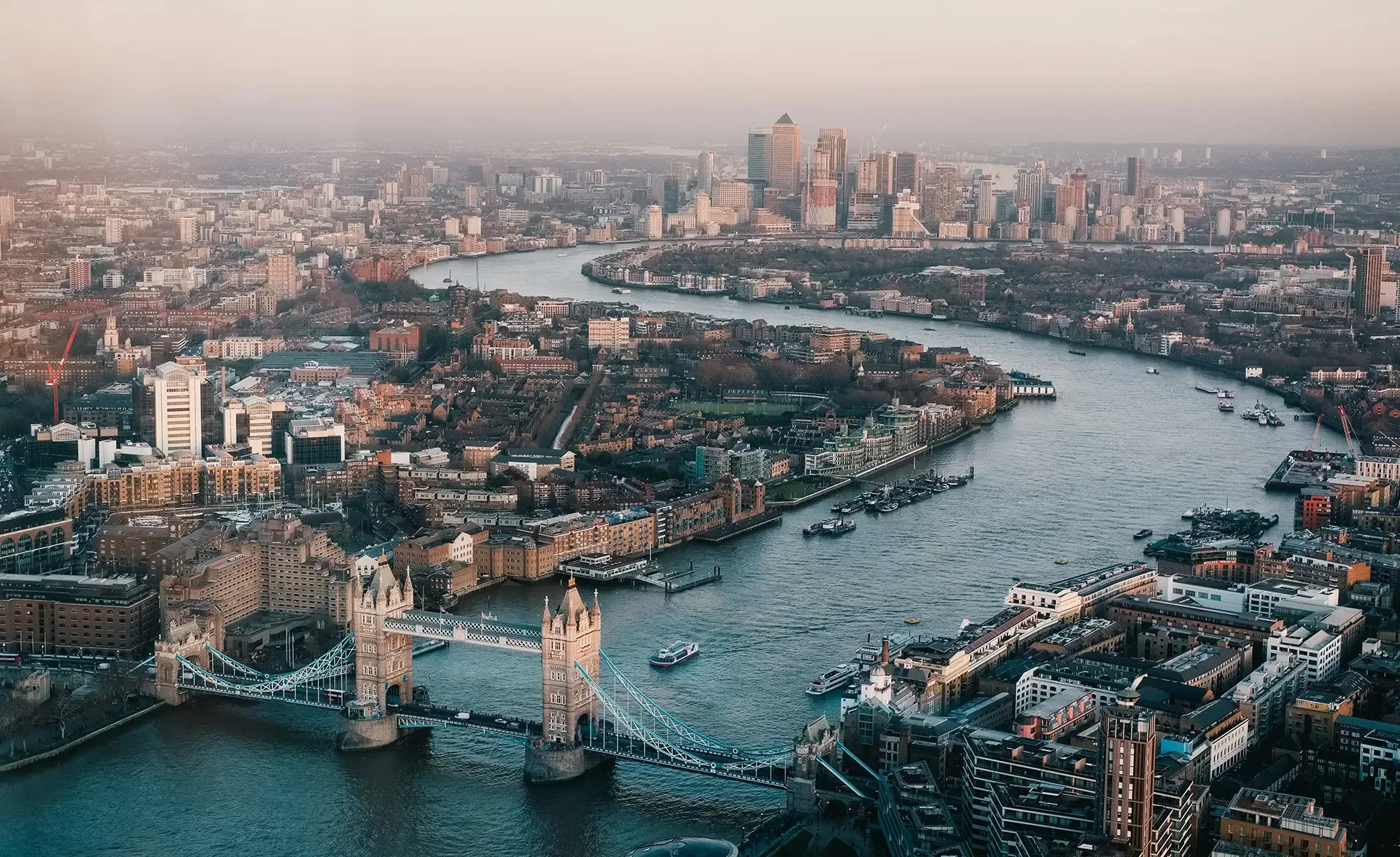 Panoramic aerial perspective of London's skyline featuring famous structures and the River Thames.