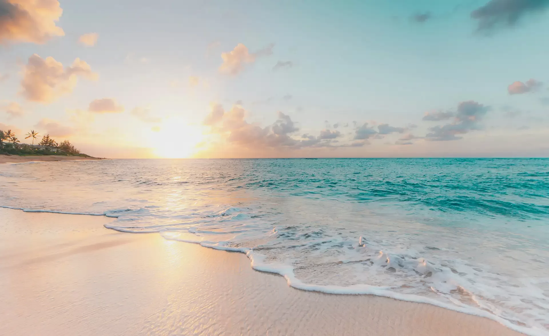 Beautiful sandy beach with clear blue skies, soft waves and sunset sky,