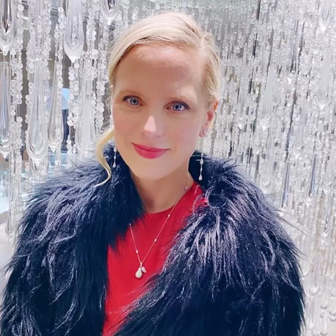 Profile shot of Lucy Cleland wearing blue feather coat