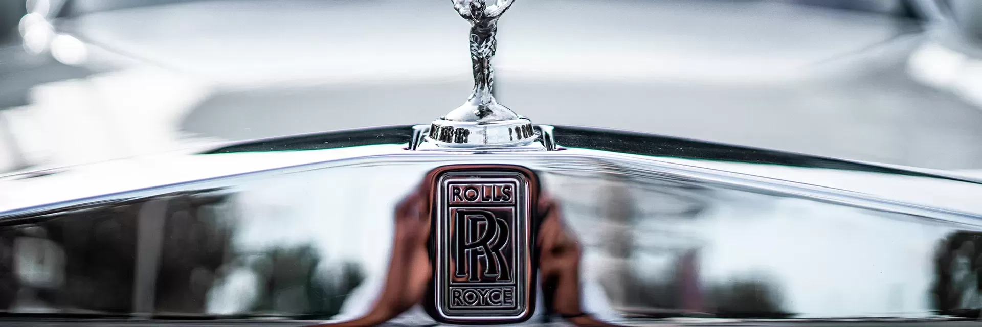 Front of silver Rolls Royce car with branded bonnet ornament