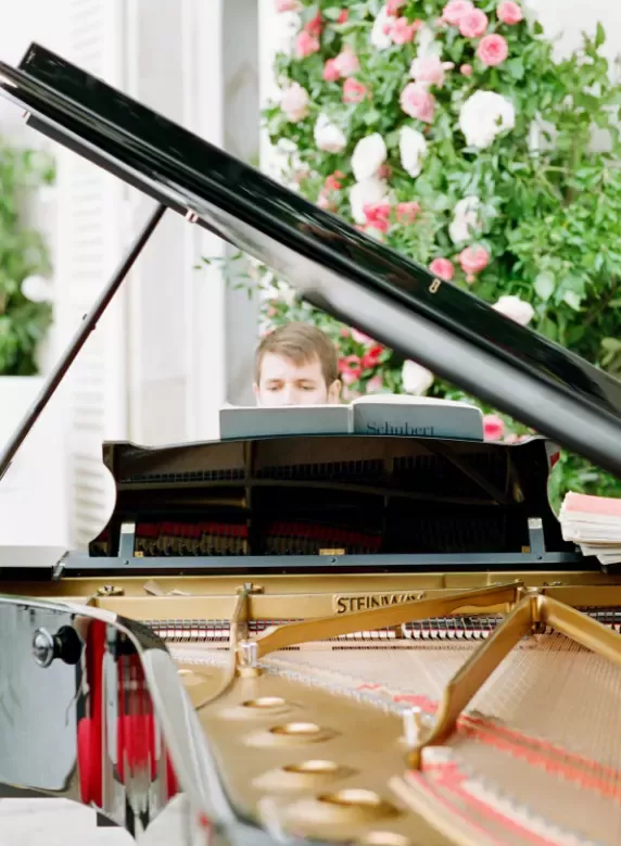 Male pianist playing grand piano