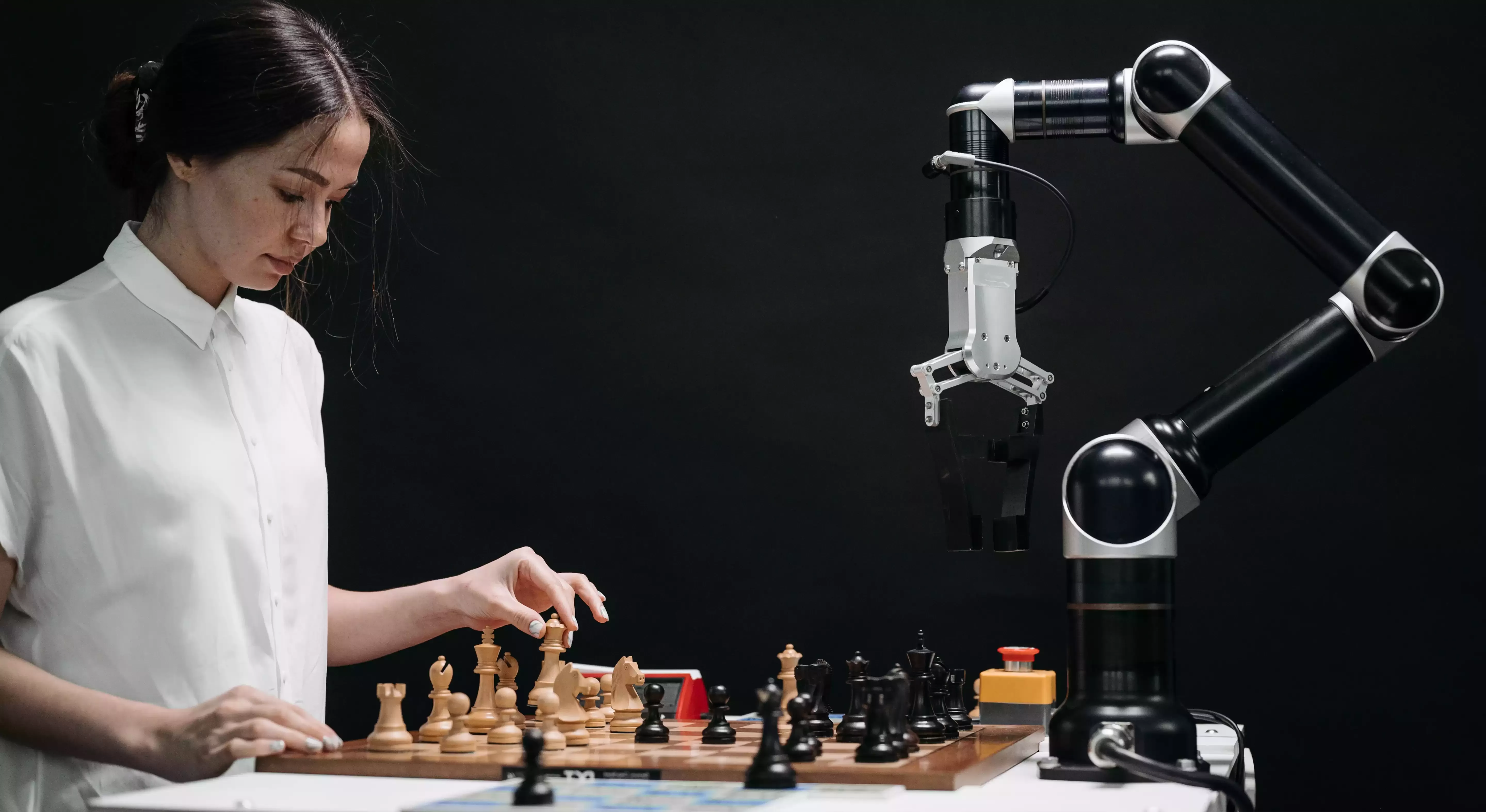 Women playing chess with robot