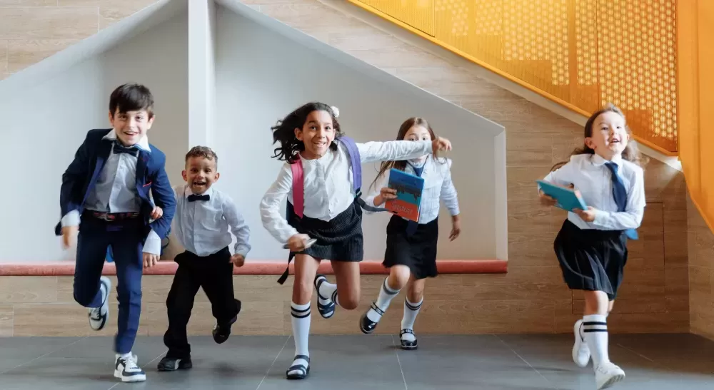 Happy children running in school uniform