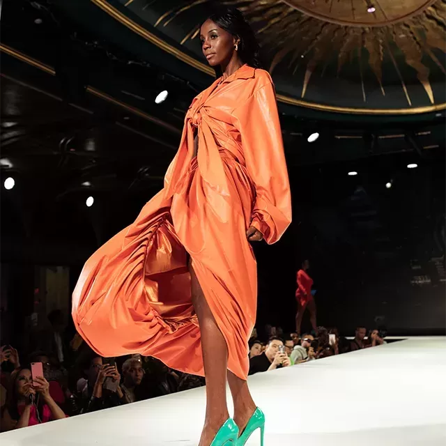 Female model walking down the catwalk in fashion clothing at New York Fashion Week