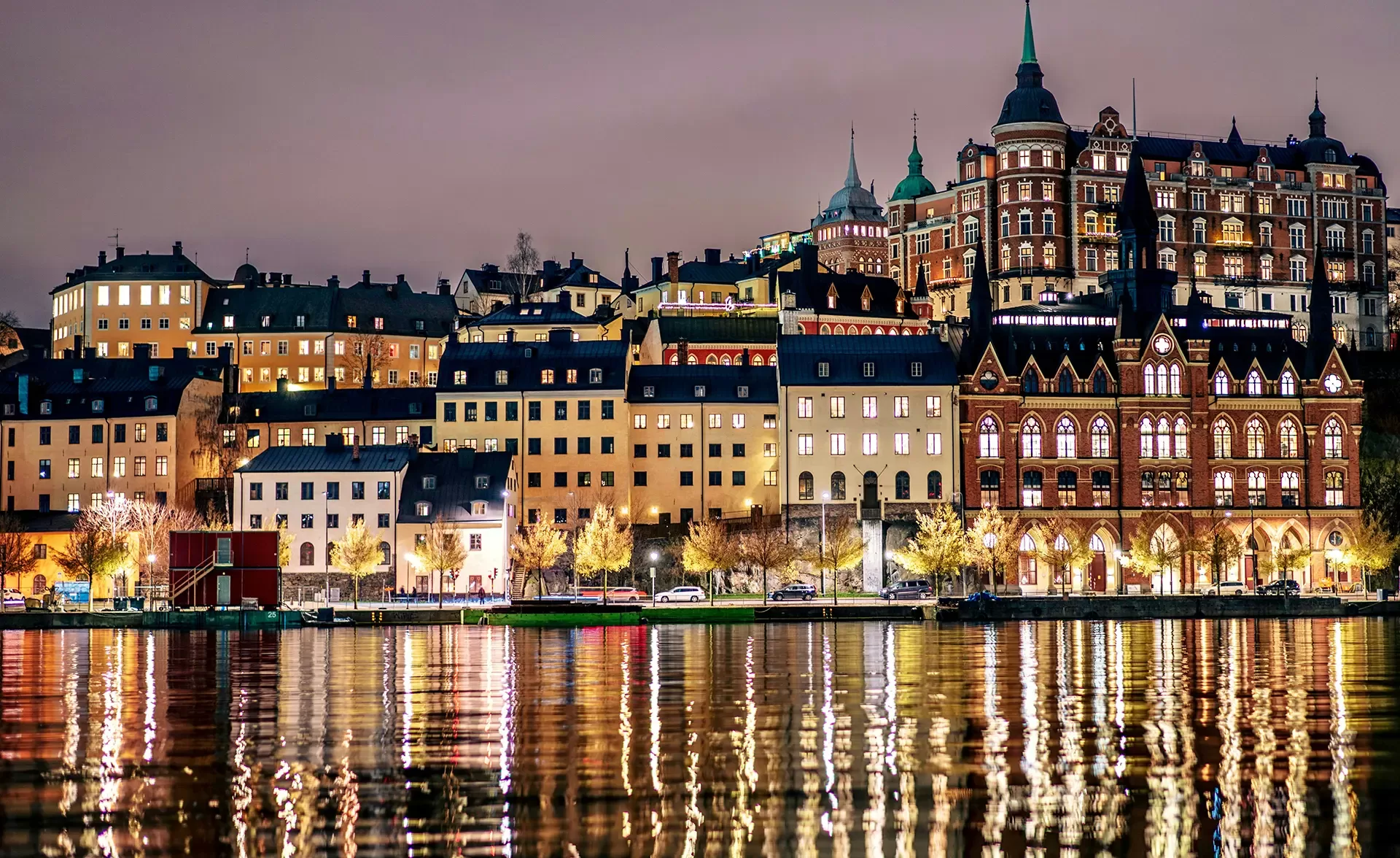 A picturesque, lit-up skyline of Stockholm at night - featuring colorful buildings and serene waters, highlighting the city's unique charm.