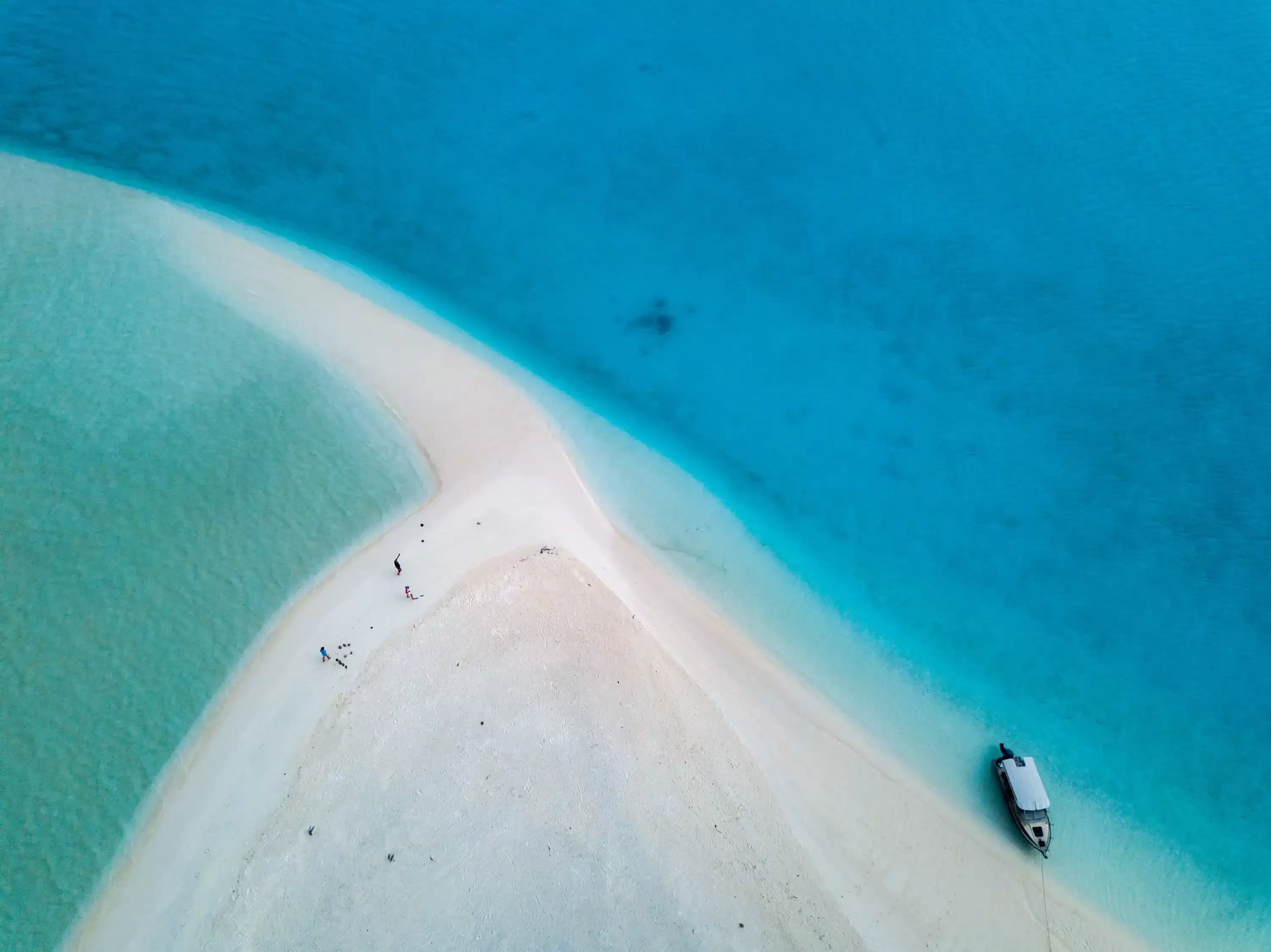 Birds eye view of sand disappearing into clear blue sea
