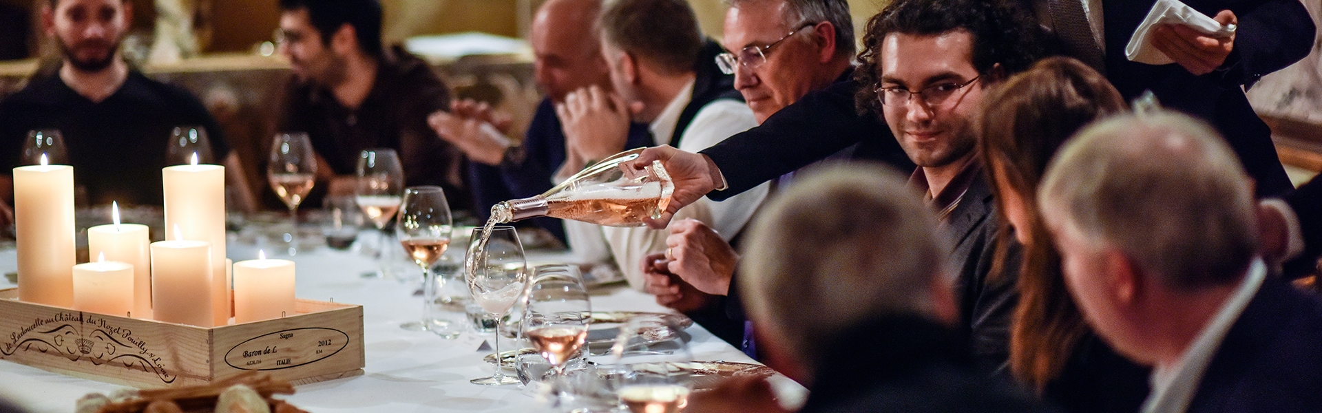 Guests sitting round a candlelit dining table