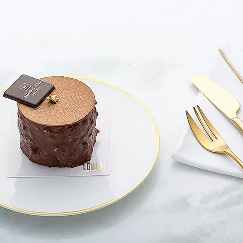 Cake served on gold trim bowl at The Raffles patisserie in Warsaw