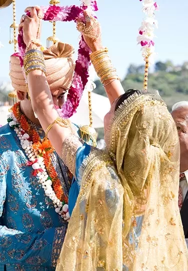 Bride and groom at Indian wedding in traditional dress with beautiful colourful decor