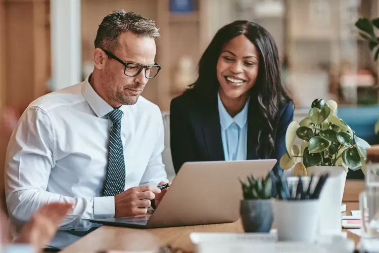 Business man and business woman looking at laptop screen