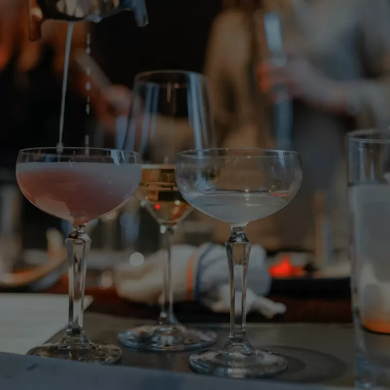 Alcohol being poured into glasses at a bar