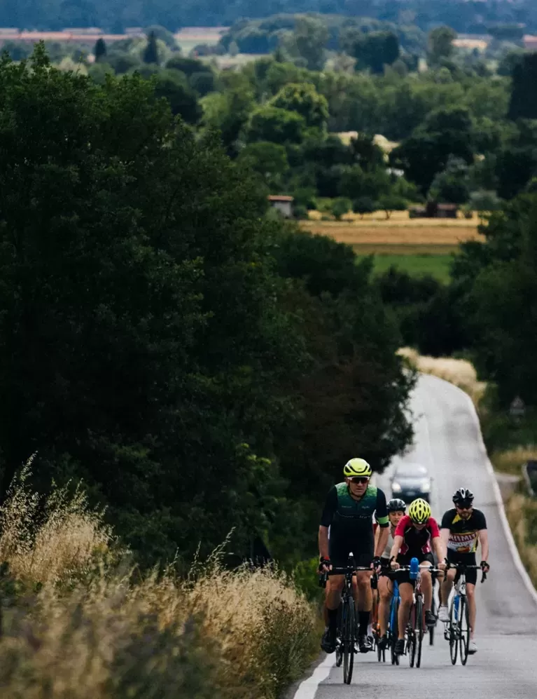 Quintessentially Foundation | group of people cycling down round
