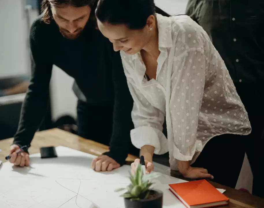 Man and woman working looking at a desk
