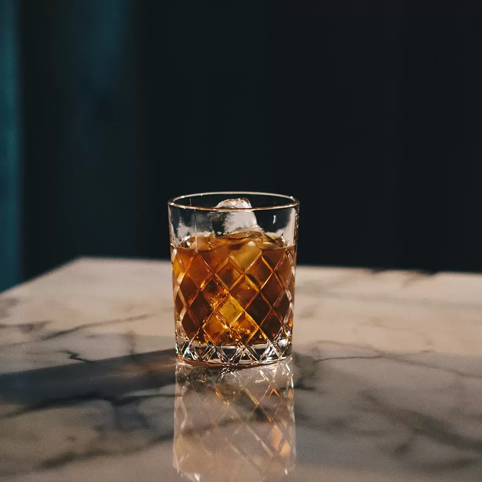 Diamond glass on a granite table filled with whisky on the rocks