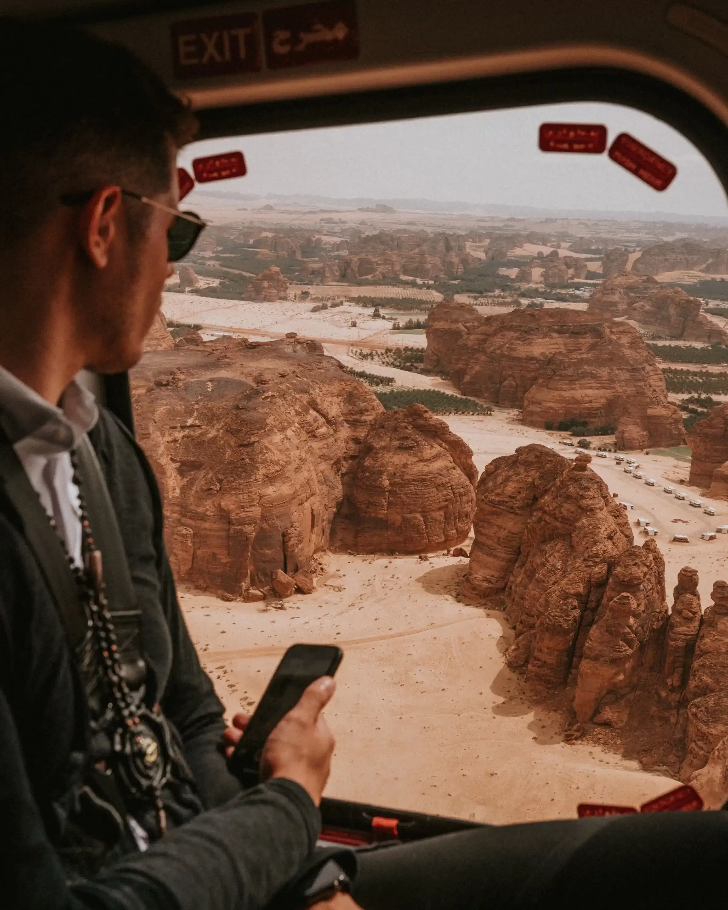 Man in plane looking out window as desert