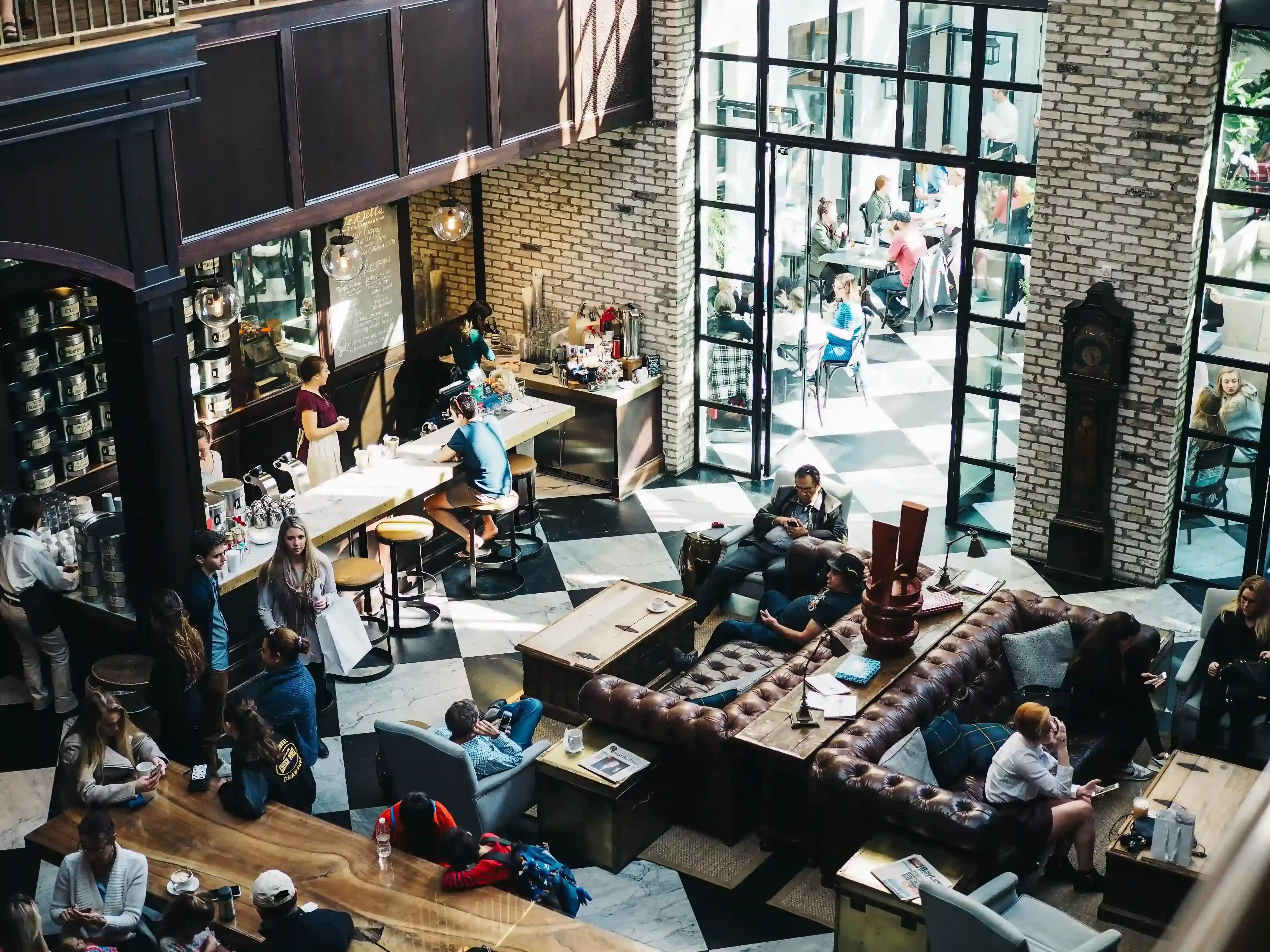 View of lots of people sitting and standing in lounge bar