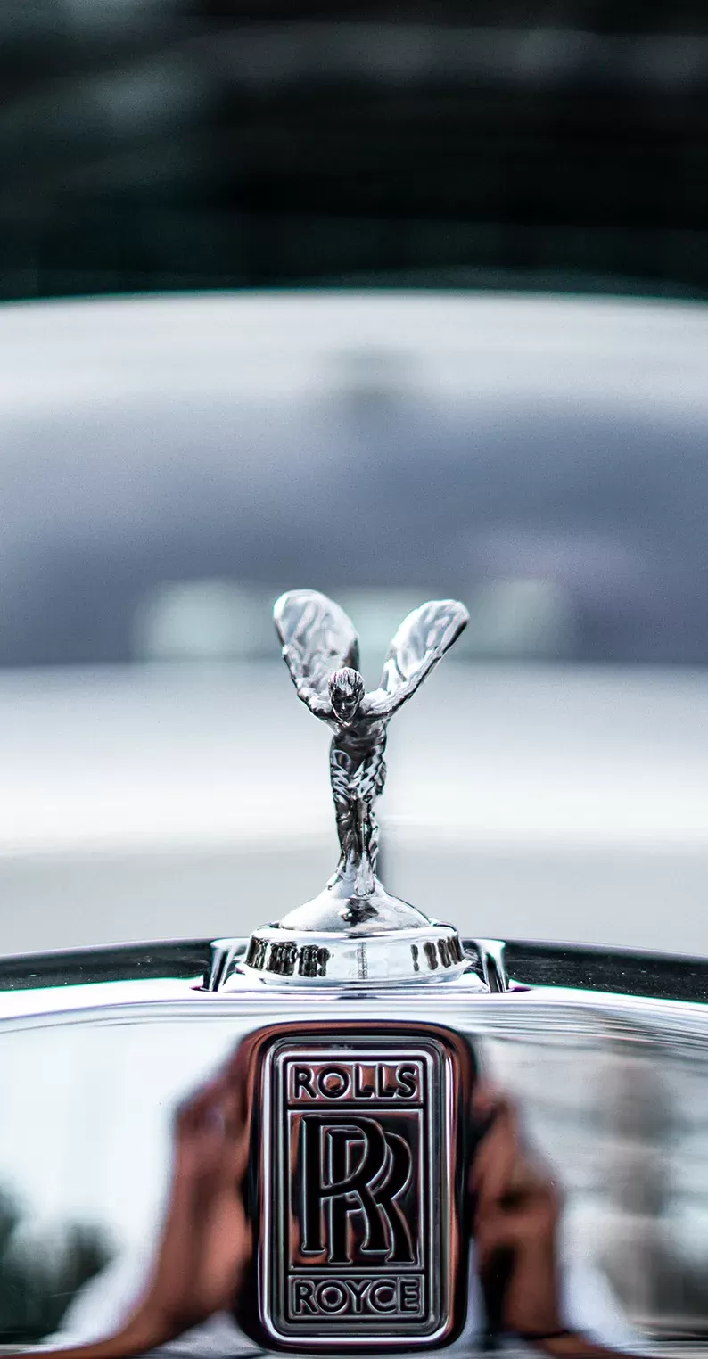 Front of silver Rolls Royce car with branded bonnet ornament
