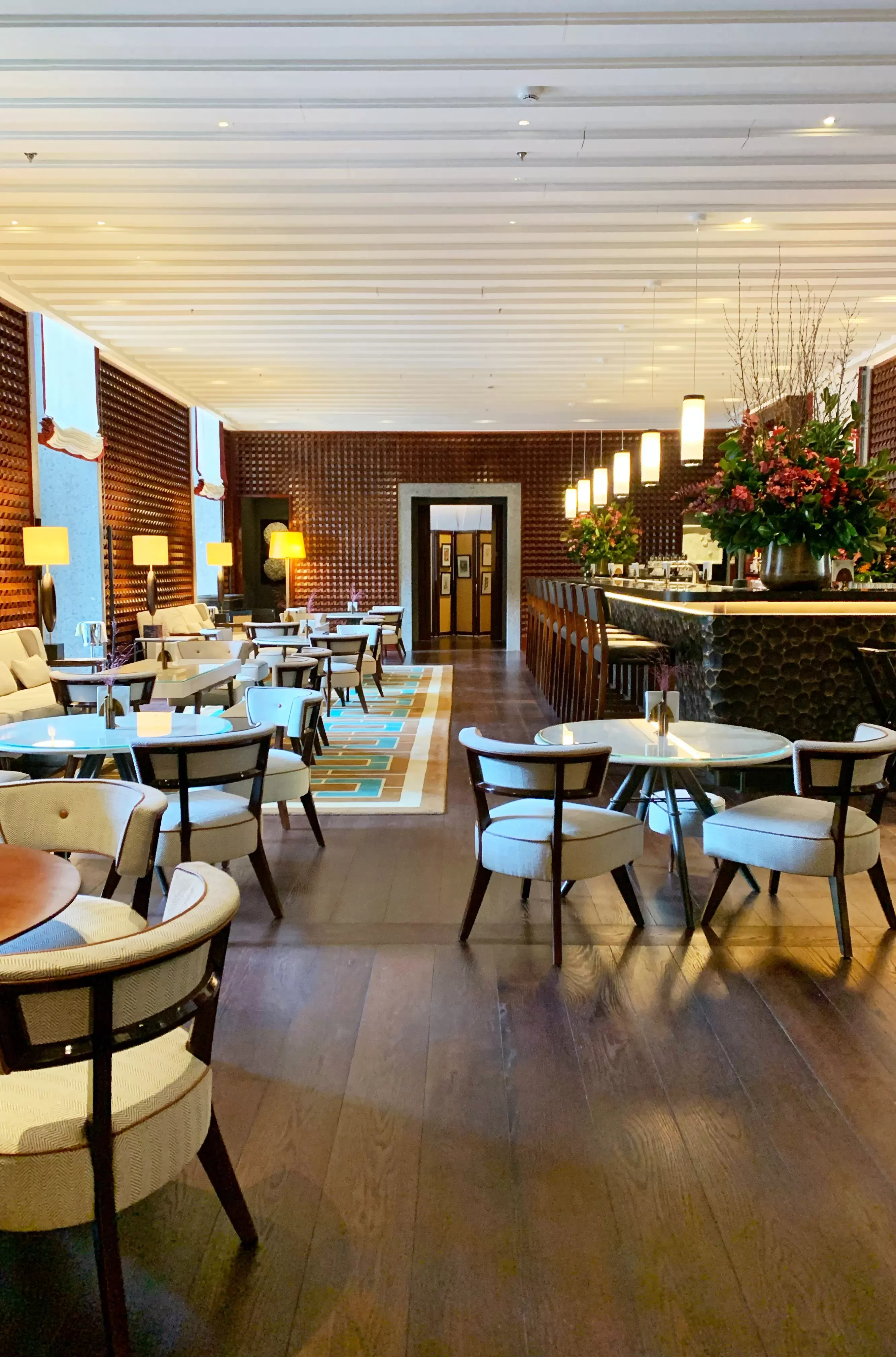 Chic interior of 10_11 Bar, Milan with rows of rounded white tables and chairs