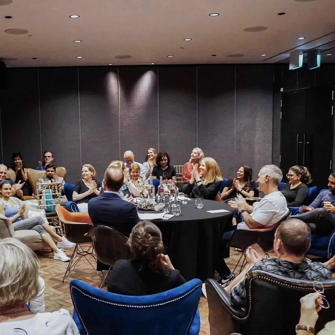 Meeting room filled with people sat down and clapping