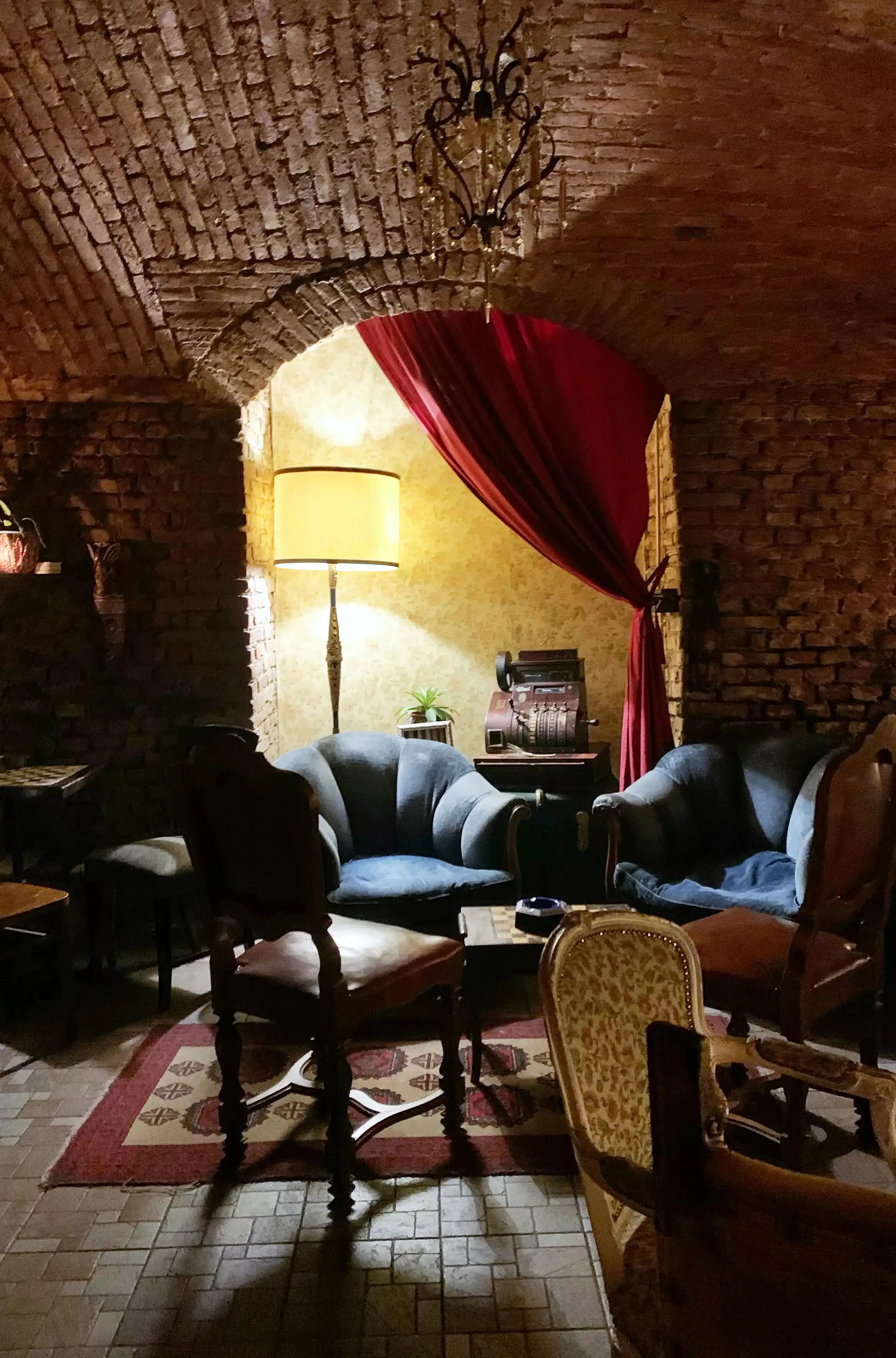 Interior vintage bar with open-brick ceiling and vintage furniture and décor at members-only 1930, Milan