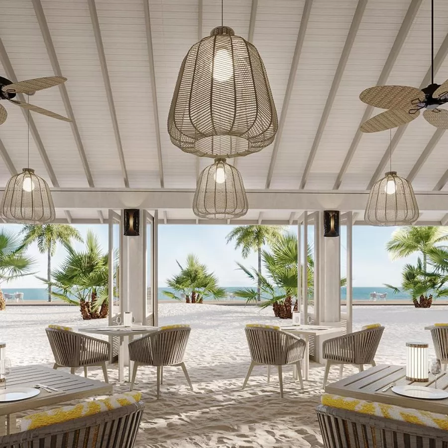 Outside white dining seating area on white sand on a beach under white roof at Anantara Velli Maldives