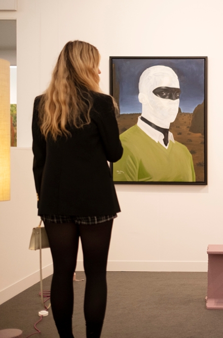Woman sanding observing a photo at Frieze