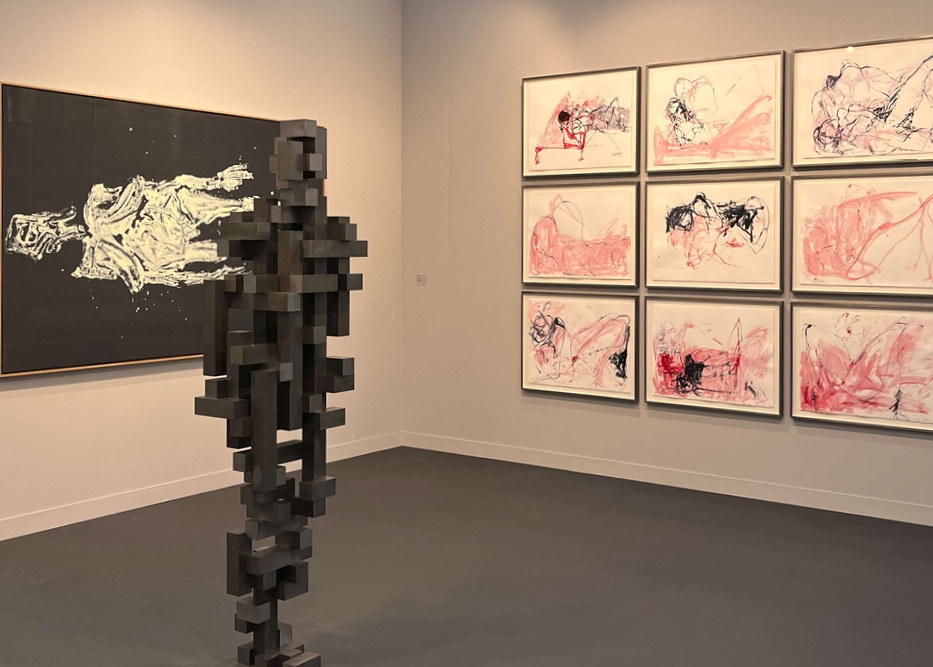 Photos hanging on the wall next to a sculpture at Frieze