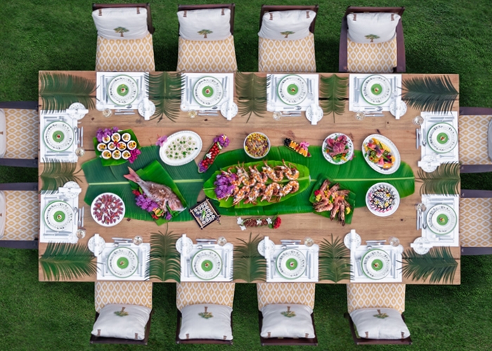 Above shot looking down on beautifully set dining table filled with food outdoors