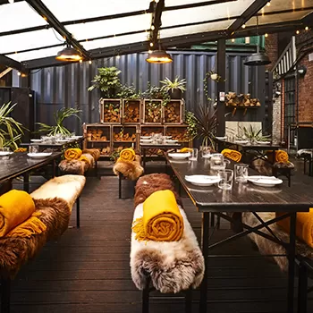 Cosy shallow interior of Acme Fire Cult, Dalston, London with fur and blanket covered seating