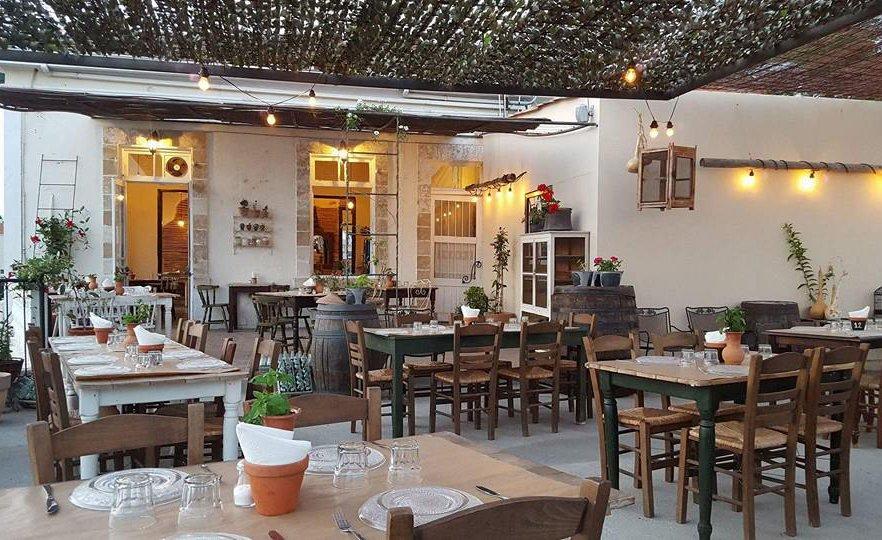 Inside tavern restaurants with array of dining tables and chairs set for dinner with floral roof.