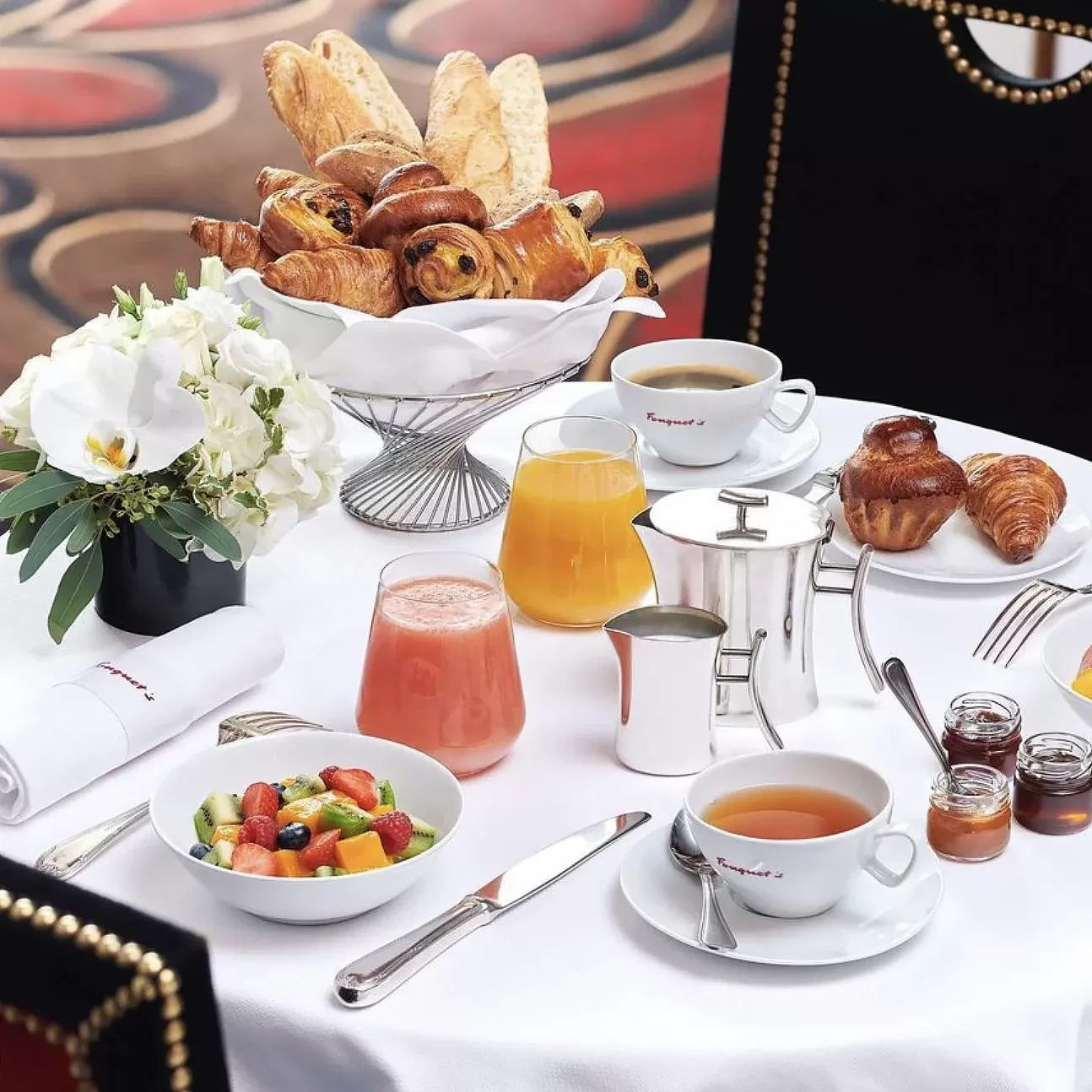 Dining table filled with selection of breakfast food, smoothies, pastries, condiments and flowers at Brasserie Fouquet's, Tribeca, New York