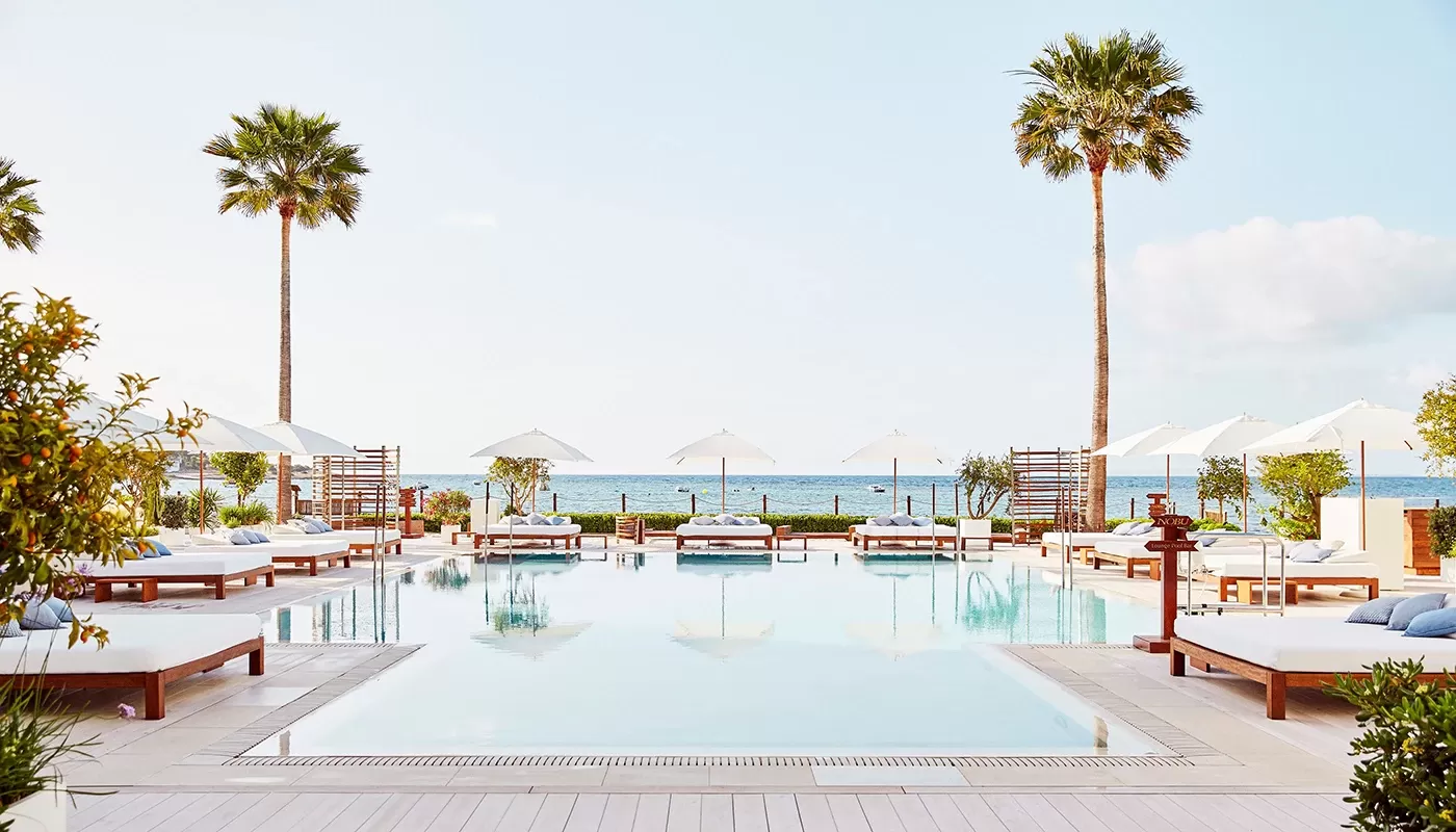 View of luxury outdoor pool with sunbeds and sea view at Nobu, Ibiza Bay