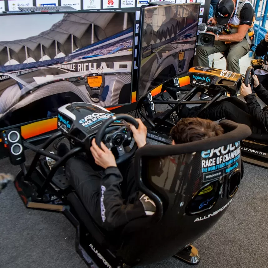 Men playing on race car simulation machine behind the Roc Snow and Ice trophies