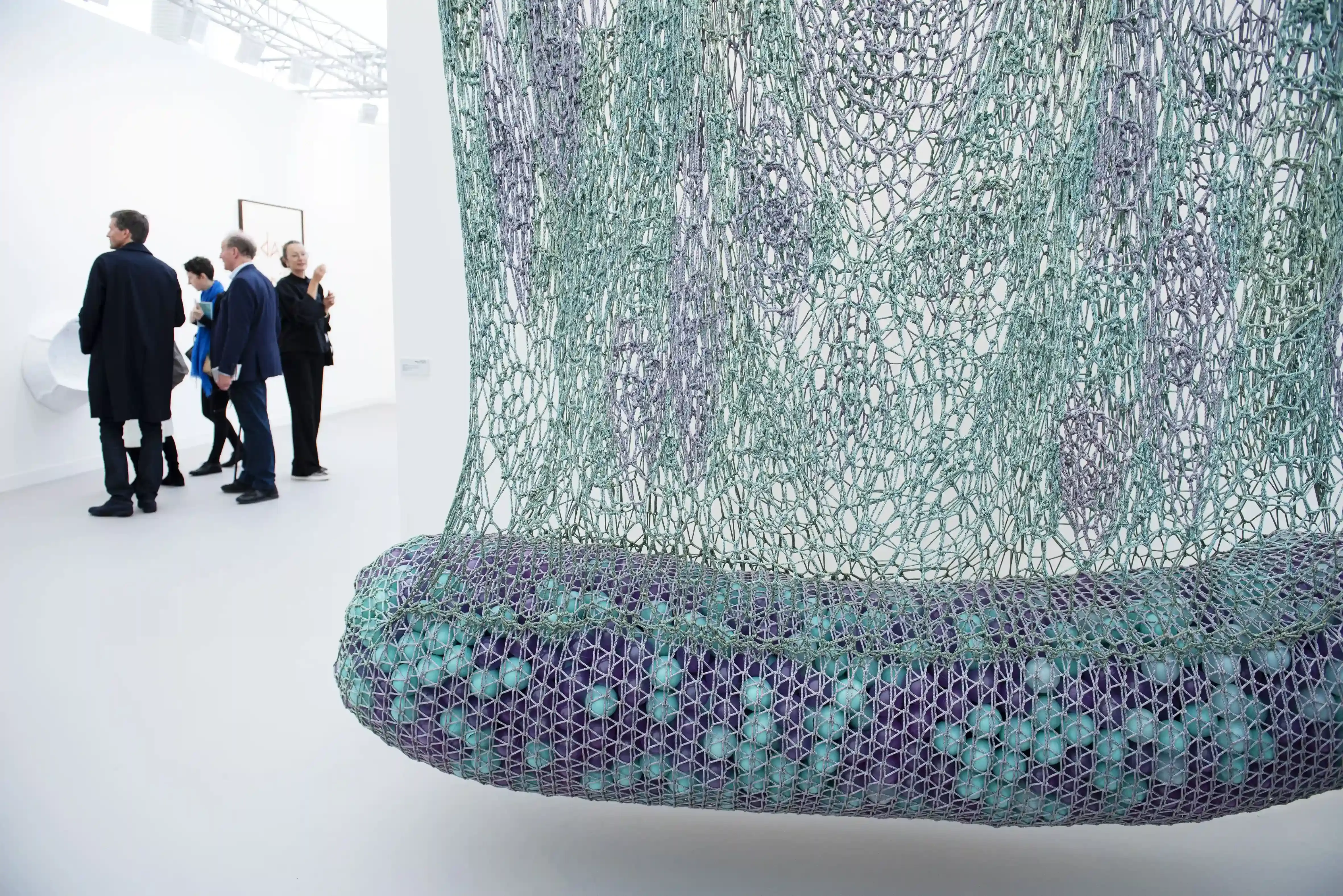 People walking through an art gallery with colourful abstract sculpture