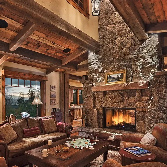 Luxurious cosy ski lodge interior with stone walls, wooden interior and wood burning fire