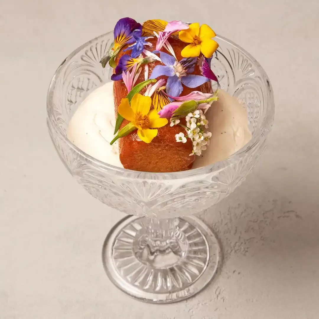 Pudding served in detailed glass with floral garnish served at HIDE, London