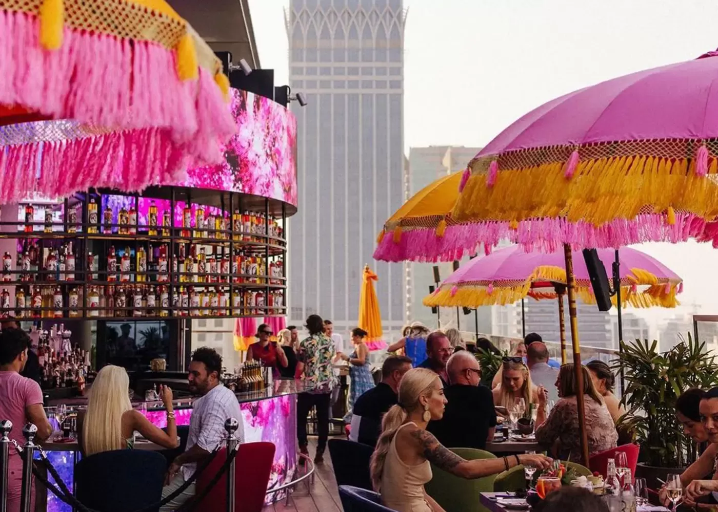 Tokyo inspired rooftop bar and brunch spot with view of Dubai city sported with yellow and pink umbrellas and people eating at Ongaku at CLAP, Dubai