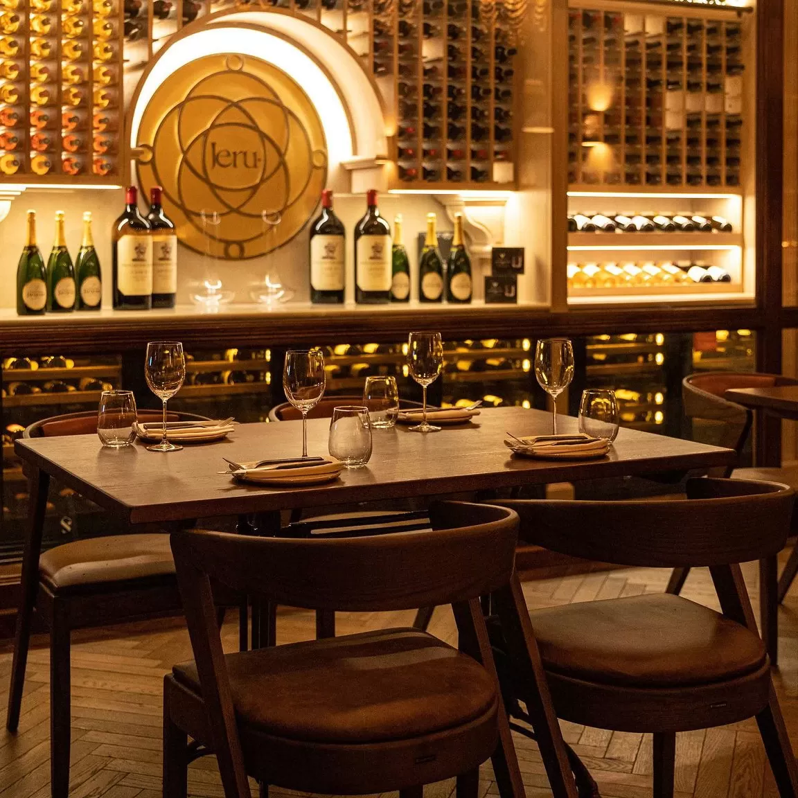 Table of four set up in a wine cellar with wine and champagne cabinets