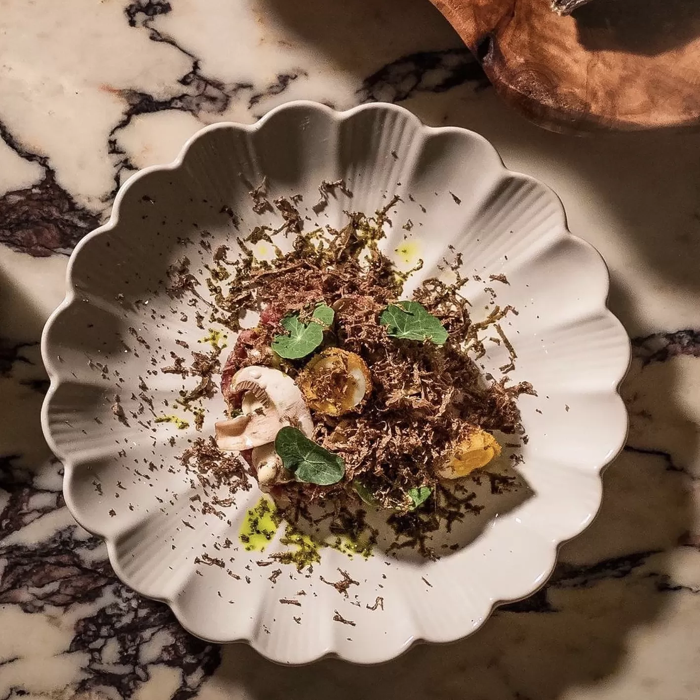 Truffle steak tartare served in a flower shaped bowl on marble table at Le Salon Cocktail Bar & Lounge, Tribeca, New York