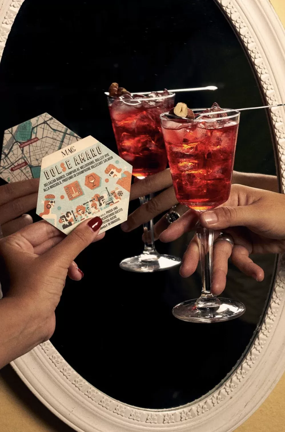 Women holding cocktail at bohemian retro coaster in front of oval mirror at MAG Café, Milan