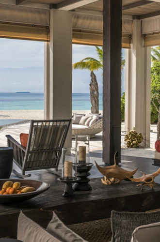 Beach view room looking onto white sand beach, palm trees and blue seas