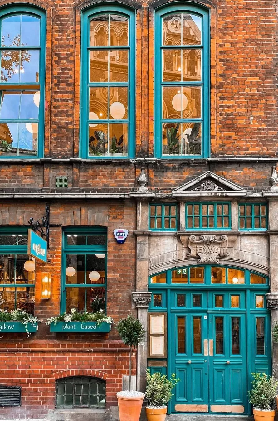 Restaurant front brick interior with blue windows and doors with flowers at Mildreds, London