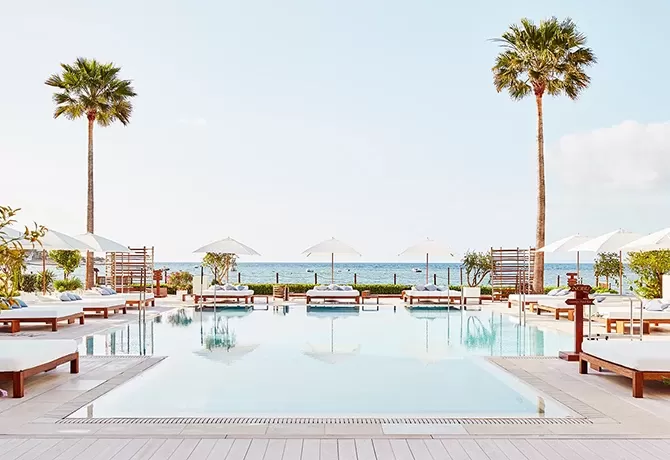 View of luxury outdoor pool with sunbeds and sea view at Nobu, Ibiza Bay