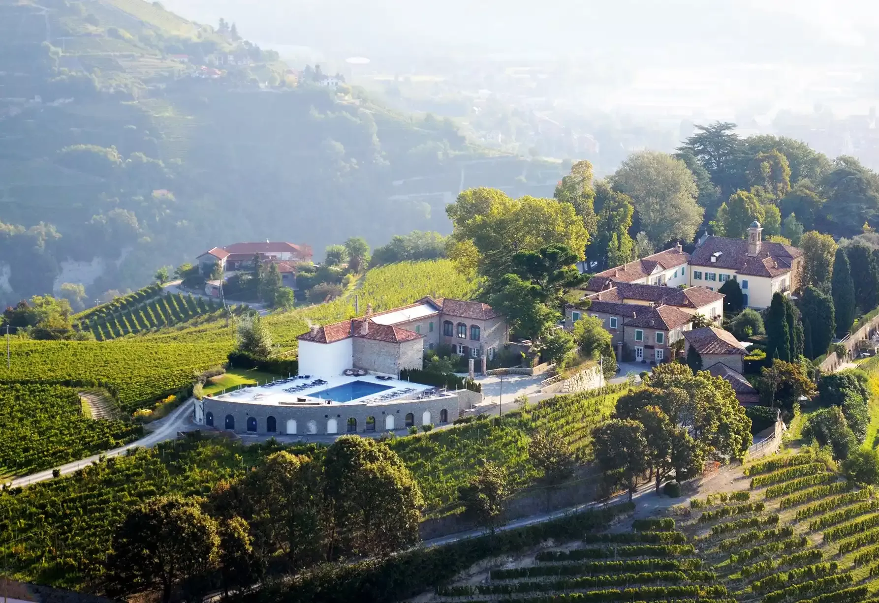 Exterior of Relais San Maurizio grand building amongst mountains and greenery landscape