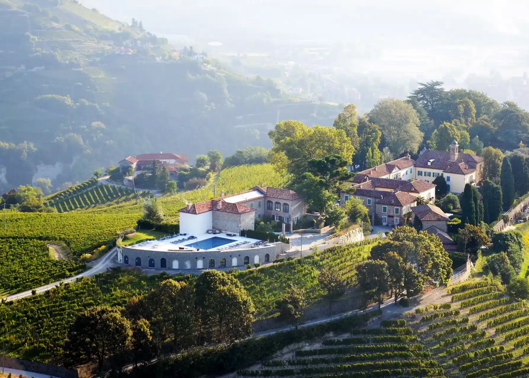 Exterior of Relais San Maurizio grand building amongst mountains and greenery landscape